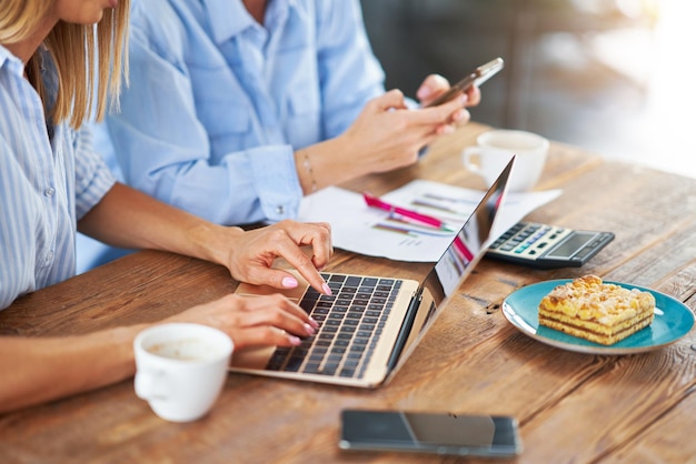 Two girl friends or lgbt couple with computer and invoice