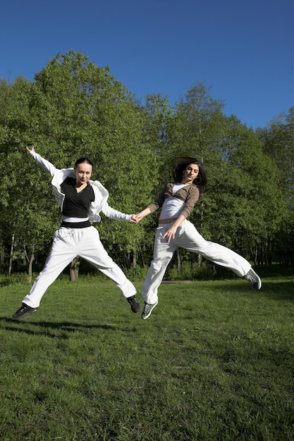 Two girl jumping in park