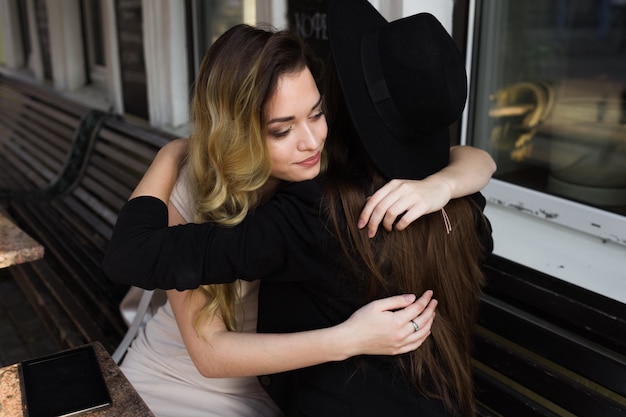 Two girlfriends hug in a public place