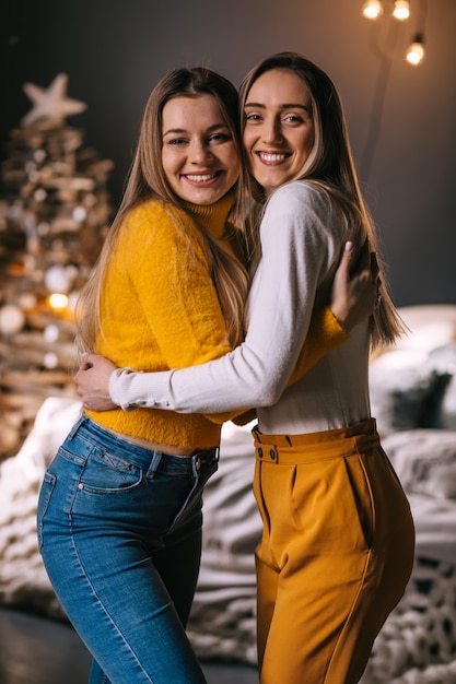 Two girls are hugging in Christmas interior