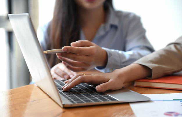 Two girls are using a laptop.