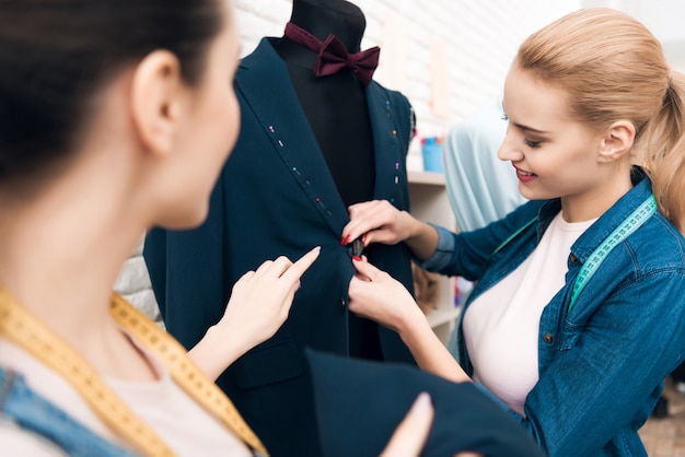 Two girls at garment factory desining new man suit jacket