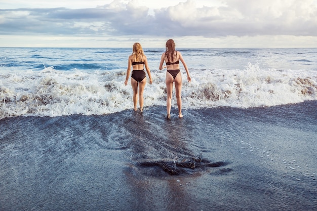 Two girls go swimming in the ocean