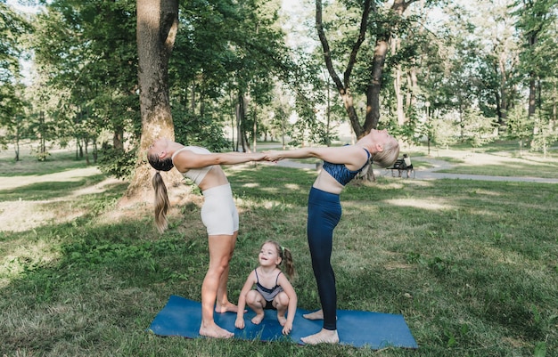 Two girls and a little girl play sports in an outdoor park. healthy lifestyle