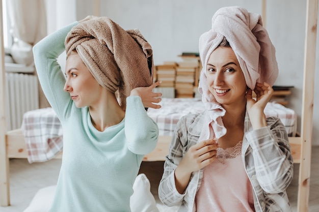 Two girls make homemade face and hair beauty masks. Cucumbers for the freshness of the skin around the eyes. Women take care of youthful skin