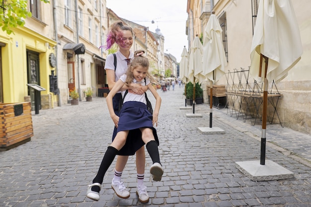 Two girls sisters having fun on the way to school