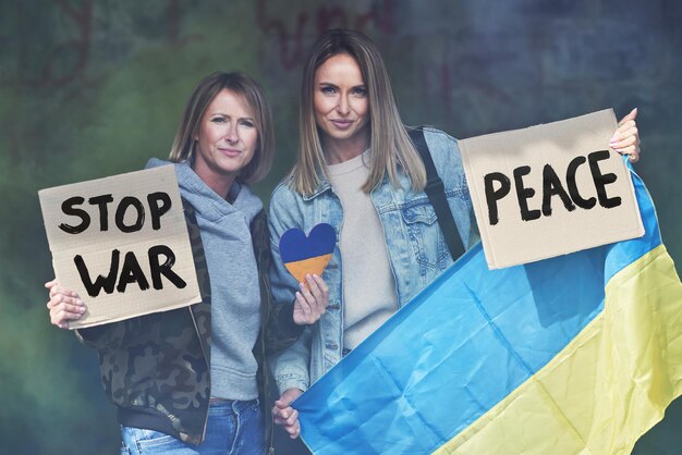 Photo two girls supports ukraine with no war signs