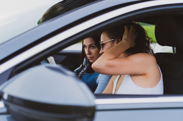 Two girls travel the roads in a car look at the map Vacation concept