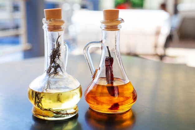 Two glass bottles with spicy and rosemary olive oil