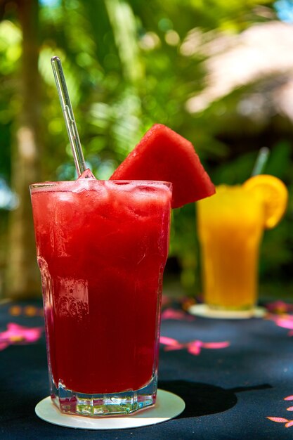 Two glass glasses with refreshing drinks from orange and watermelon juice.