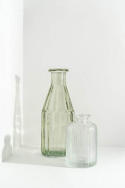 Photo two glass vases stand on a white background