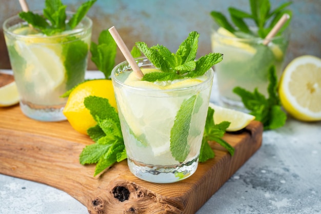 Two glass with lemonade or mojito cocktail with lemon and mint cold refreshing drink or beverage wit...