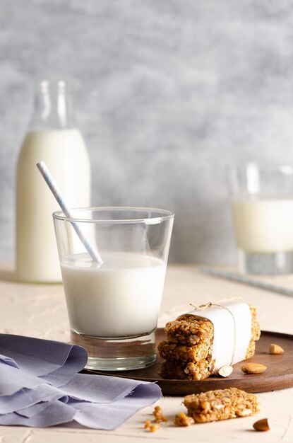 Two glasses and a bottle of milk and cereal bars with a light blue napkin