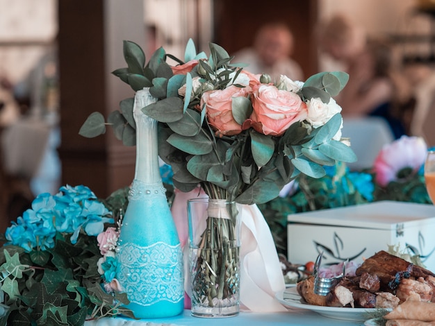 Two glasses of champagne on the background of the wedding bouquet of pink roses. Soft focus, selective focus