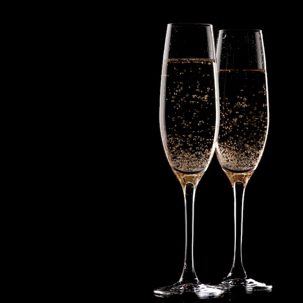 Two glasses of champagne over black background