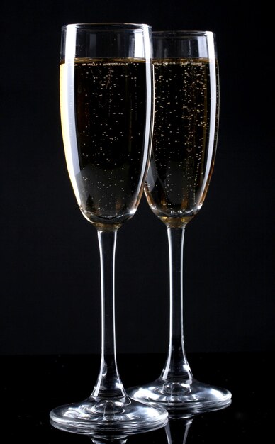 Two glasses of champagne on black background