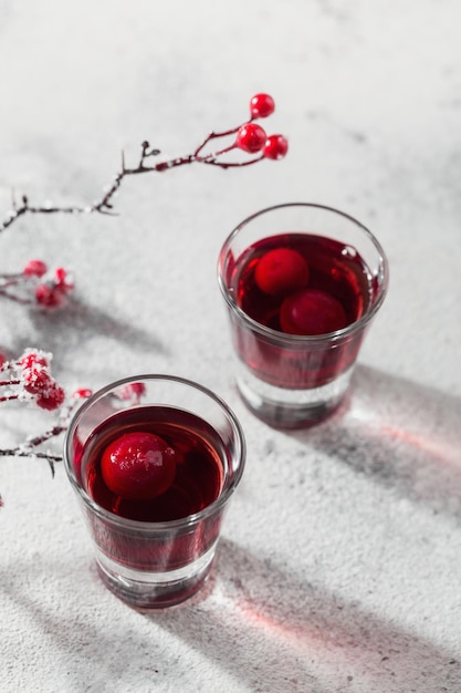 Two glasses of cherry liqueur on white background