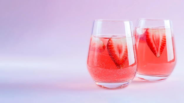 Two glasses of Cooling strawberry Sangria with sparkling wine, strawberry, ice cubes in champagne glass