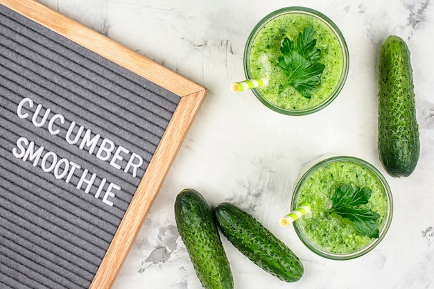 two glasses of cucumber smoothie. Freshly squeezed cucumber juice with lime and avocado. Flat lay.