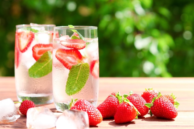 Two glasses of fresh strawberry lemonade with ice and mint Summer refreshment drinks