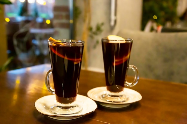 Two glasses of mulled wine on the table surrounded by New Year's lights Festive mood