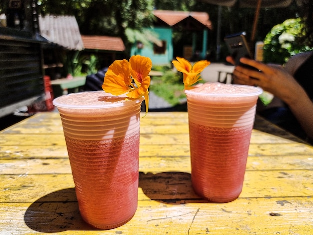 Two glasses of natural juice decorated with flowers