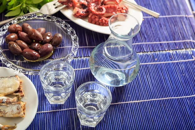 Two glasses of ouzo and appetizers