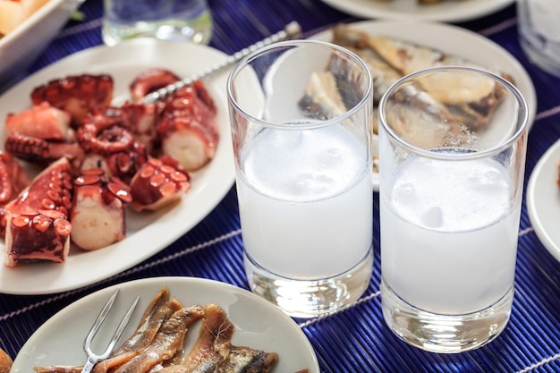 Two glasses of ouzo and appetizers