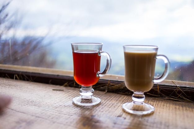 Two glasses of red and milk hot drink in the mountains