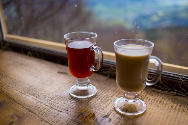 Two glasses of red and milk hot drink in the mountains