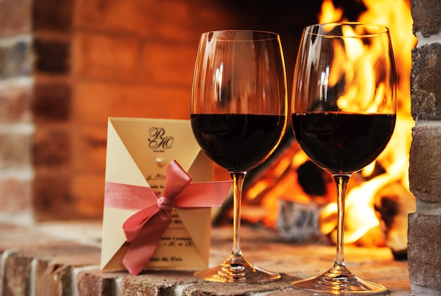 Two glasses of red wine and decorative postcard