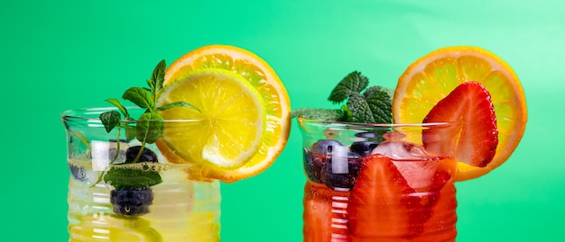 two glasses of refreshing summer lemonade with ice. Cocktail with strawberry and lemon and cocktail with lemon and lime