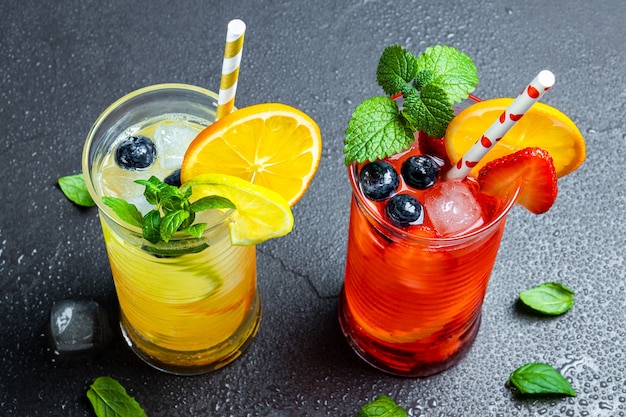 Two glasses of refreshing summer lemonade with ice cocktail with strawberry and lemon and cocktail