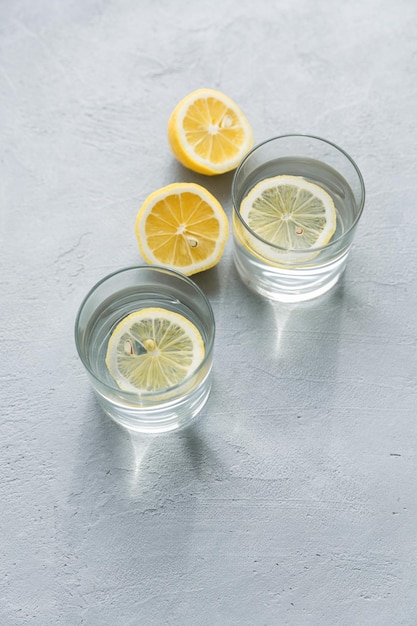 Two glasses of water with lemon slices Lemon citrus water Refreshing cold summer drink