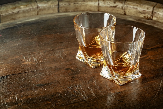 Two glasses of whiskey on a wooden table in the bar