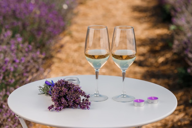 Two Glasses of white wine in a lavender field in Provance Violet flowers on the background