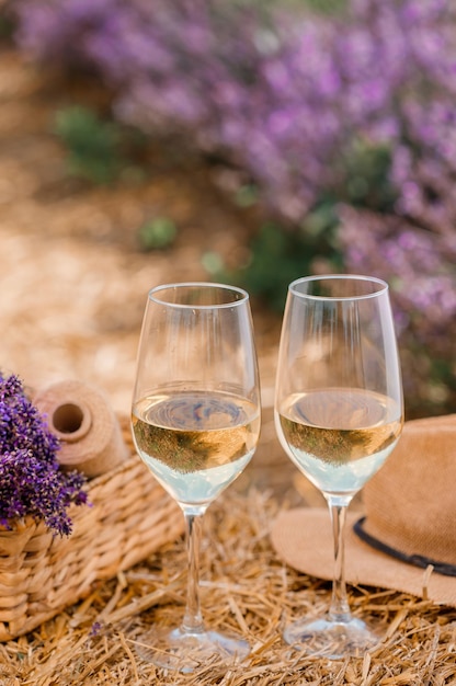 Two Glasses of white wine in a lavender field in Provance Violet flowers on the background