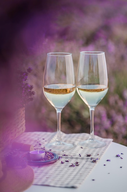 Two Glasses of white wine in a lavender field in Provance Violet flowers on the background