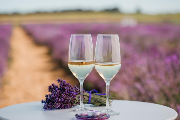 Two Glasses of white wine in a lavender field in Provance Violet flowers on the background