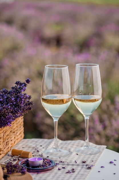 Two Glasses of white wine in a lavender field in Provance Violet flowers on the background