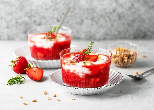 Two glasses with cold summer dessert Strawberry sauce and yoghurt cream