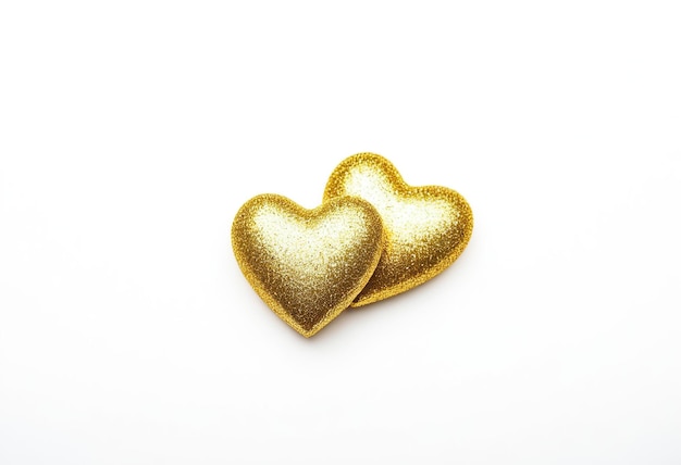 two gold hearts are placed on a white background