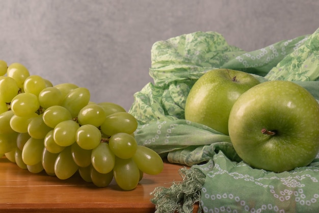 Two green apples a large bunch of green grapes on a wooden table Proper nutrition vitamin diet Excess weight Vegan Beautiful body