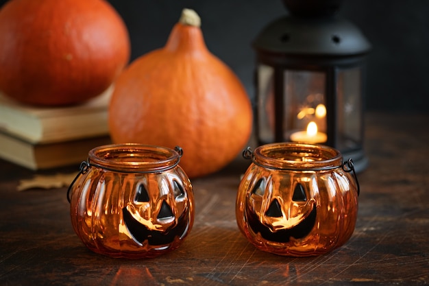 Two Halloween pumpkins head jack glass lantern. Halloween decoration on wooden table background, selective focus - Image