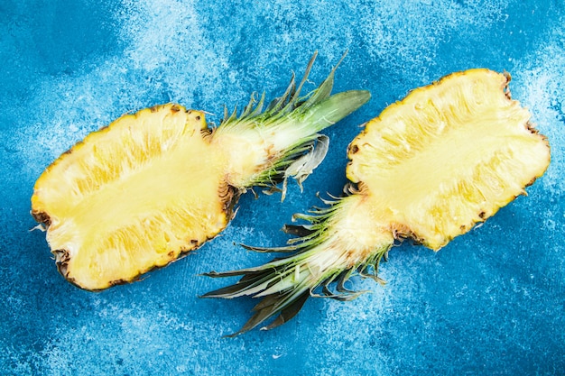 Two halves of pineapple on a blue background