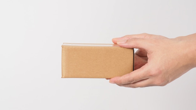 Two Hand is holding brown box on white background.