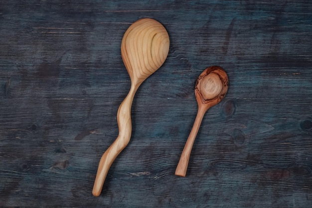 Two handmade wooden spoons on wooden background