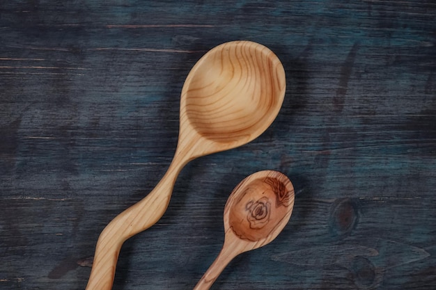 Two handmade wooden spoons on wooden background