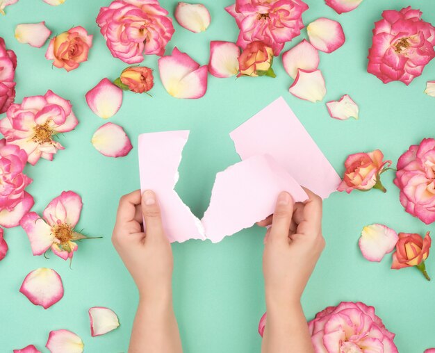 Photo two hands hold an empty pink sheet torn from notebook