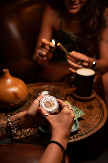 Photo two hands holding a bottle of beer and a cup with the lid open